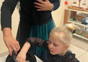 dziewczynka częstuje się cukierkiem i miotełką