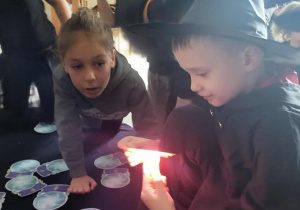 chłopiec podświetla latarką kule i mówi co to za zawód