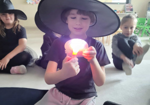 chłopiec podświetla latarką kule i mówi co to za zawód