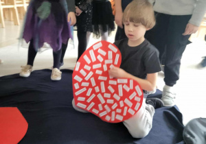 chłopiec próbuje przeczytać wylosowane imię dziewczyny