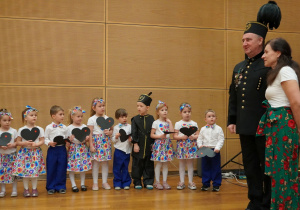 dzieci trzymają w dłoniach czarne serca