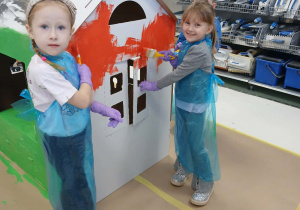 Dziewczynki malują ścianę na czerwono