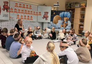 dzieci siedzą w kole i słuchają listu od misia