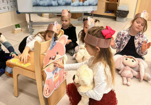 dziewczynka karmi misia miodem