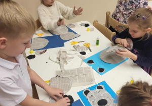 dzieci wykonują pracę plastyczną misia