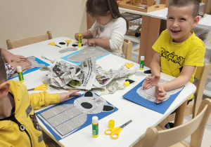 dzieci wycinają i przyklejają elementy misia