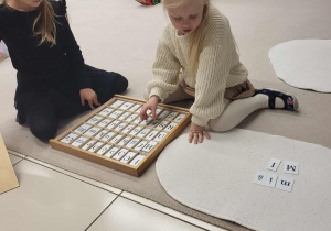 dziewczynka układa z literek wyraz miś