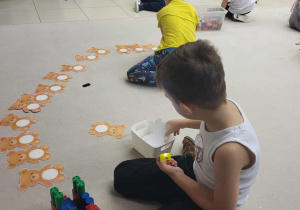 chłopcy sprawdzają latarkami co ukryło się w brzuszkach misiów