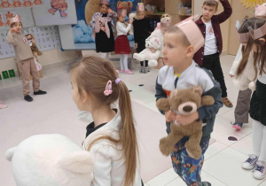 przedszkolaki idą z misiami w kole śpiewając piosenkę
