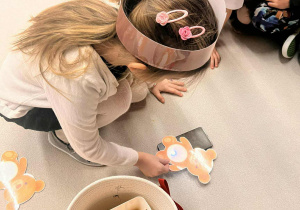 dziewczynka sprawdza co kryje się w brzuszku misia