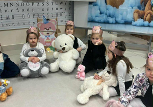 dzieci siedzą ze swoimi misiami