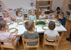 dzieci siedzą przy stolikach