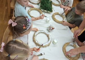 dzieci smarują wianki klejem