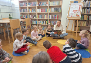 dzieci słuchaja jak pani czyta książkę