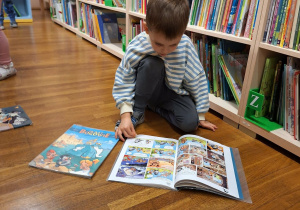 chłopiec ogląda książkę