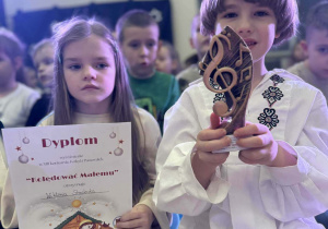 chłopiec pokazuje trofeum za zajęcie I miejsca