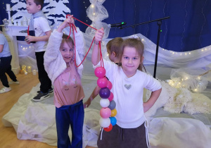 dziewczynki nawlekają piłki i tworzą łańcuch