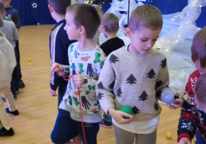 chłopcy nawlekają piłki tworząc łańcuch