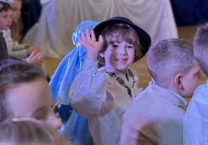 chłopiec macha ręką