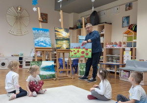 pan opowiada dzieciom o obrazach