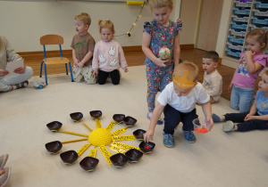 chłopiec wkłada czerwone koraliki do miseczek