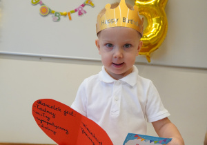 chłopiec trzyma dyplom i serce