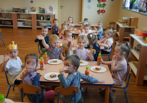 dzieci jedzą ciasto i piją soki