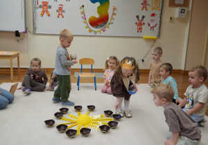 dziewczynka wkłada koraliki do miseczek