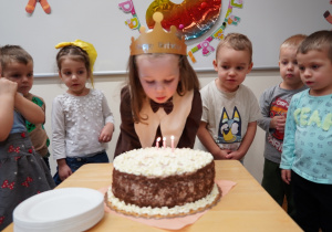 dziewczynka zdmuchuje świeczki