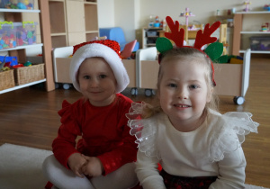 dwie dziewczynki siedzą na dywanie