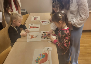 dziewczynki przy pomocy uczenic liceum podpisują obrazki związane ze świętami