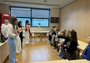 dzieci stoją na przeciw uczenic i biorą udział w zabawie ruchowej w jęzku angielskim