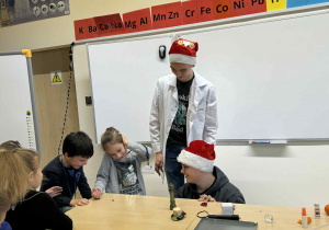 uczniowe technikum demonstrują dzieciom przy stoliku eksperyment z magnesme