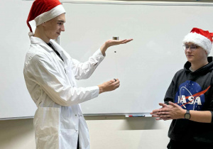 uczniowe technikum pokazują dzieciom ekperyment z lewitującym magnesem