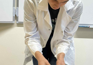 uczeń technikum pokazuje eksperyment ze skórką pomarańczy i świeczką