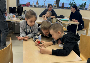 chłopcy ogladają opiłki siarki jak zachowują się w rekacji z magnesem