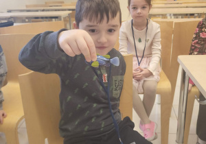 chłopiec trzyma w ręku rybkę zabwkę