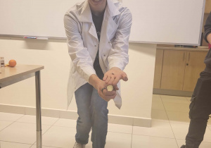 uczeń w czpace mikołaja ma na dłoni magnes