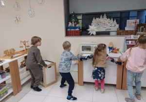 dzieci ustawiają meble na swoje miejsce