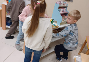 dzieci ustawiają meble na swoje miejsce
