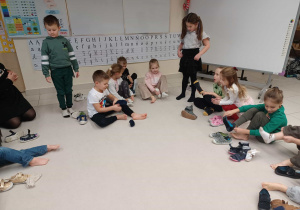 dzieci wykonują zadanie od elfa, siągając buty i skarpetki