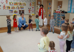 dzieci stoją w kole i słuchają piosenki