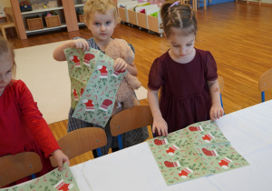 dziewczynki układają serwetki na stole