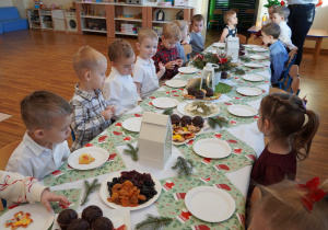 dzieci siedzą przy wigilijnym stole