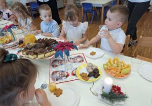 dzieci siedza przy wigilijnym stole