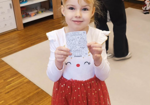 Dziewczynka pokzauje znaleziony obrazek