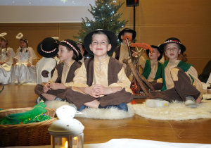 chłopcy w roli pasterzy siedzą przy ognisku