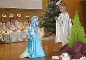 dzieci grają role Archanioła Gabriela i Maryi, która klęka
