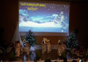 dziewczynki tańczą na scenie w ciemności ze światełkami