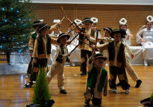 chłopcy tańczą na scenie ciupagami